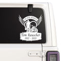 Memorial decal with a motorcycle and text on a car window.
