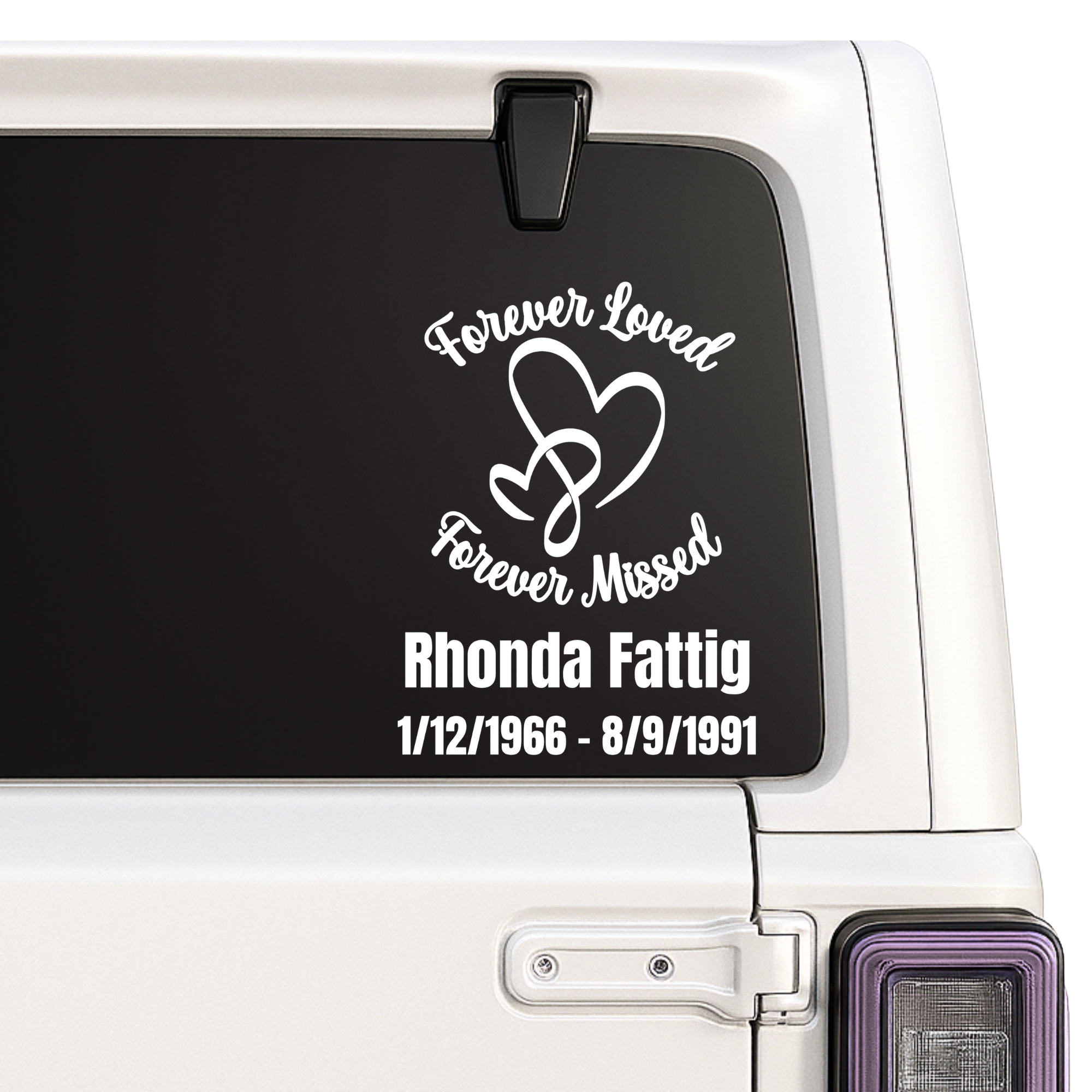 Memorial decal with 'Forever Loved, Forever Missed' text on a car window.