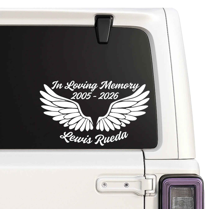 Memorial decal with wings and text on a car window