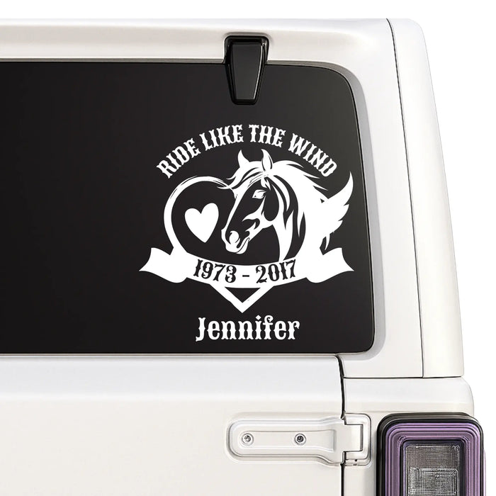 Car window with a decal featuring a horse and text on a black background