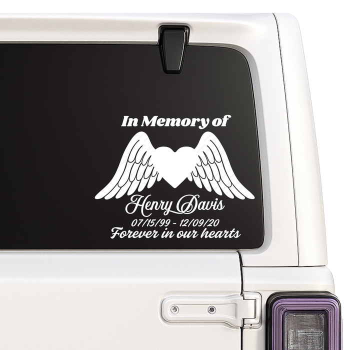 Memorial decal with wings and text on a car window