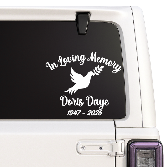 Memorial decal with 'In Loving Memory' text and dove design on a vehicle window.
