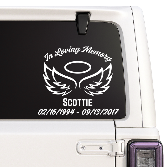Memorial decal with wings and text on a car window