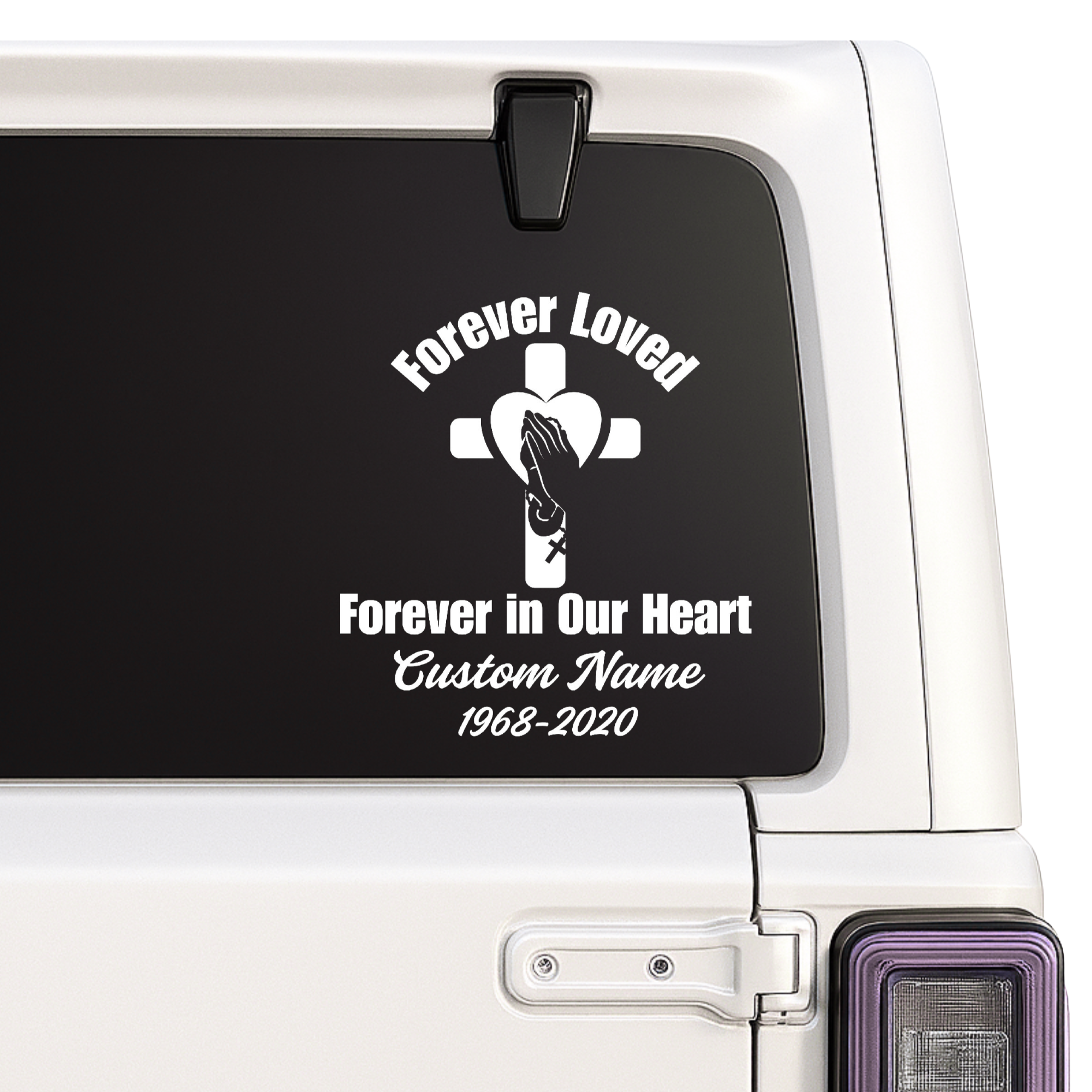 Memorial decal with cross and hands on a car window.