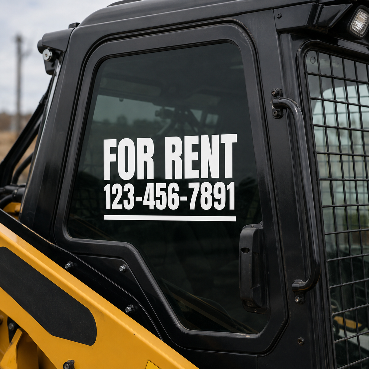 Window of a yellow and black machine with 'For Rent' and contact number decal.