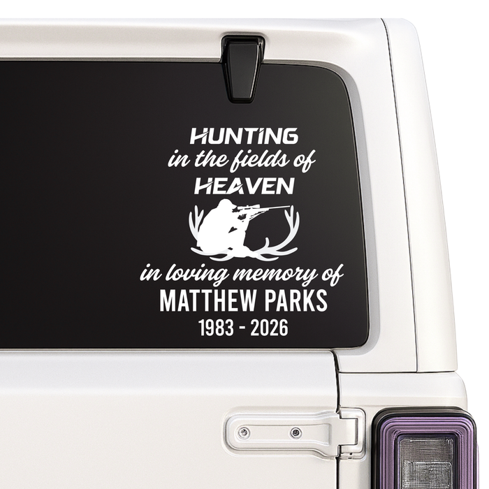 Memorial decal with text and silhouette of a deer on a vehicle window.
