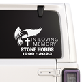 Memorial decal with an eagle, cross, and text on a car window.