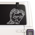 Memorial decal of an angel holding a heart with engraved text on a vehicle window.