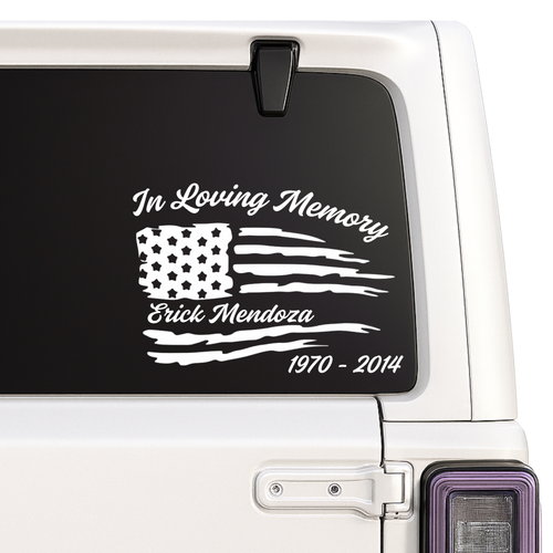 Memorial decal with American flag design on a vehicle window.