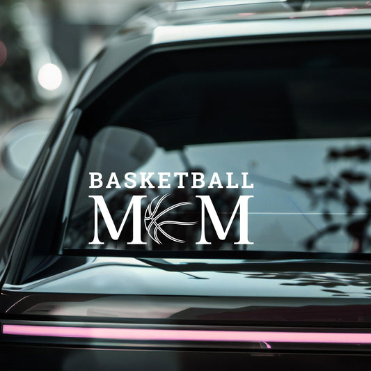 Nostalgi Factory basketball mom vinyl car decal sticker displayed on a vehicle window with bold basketball and mom text design.